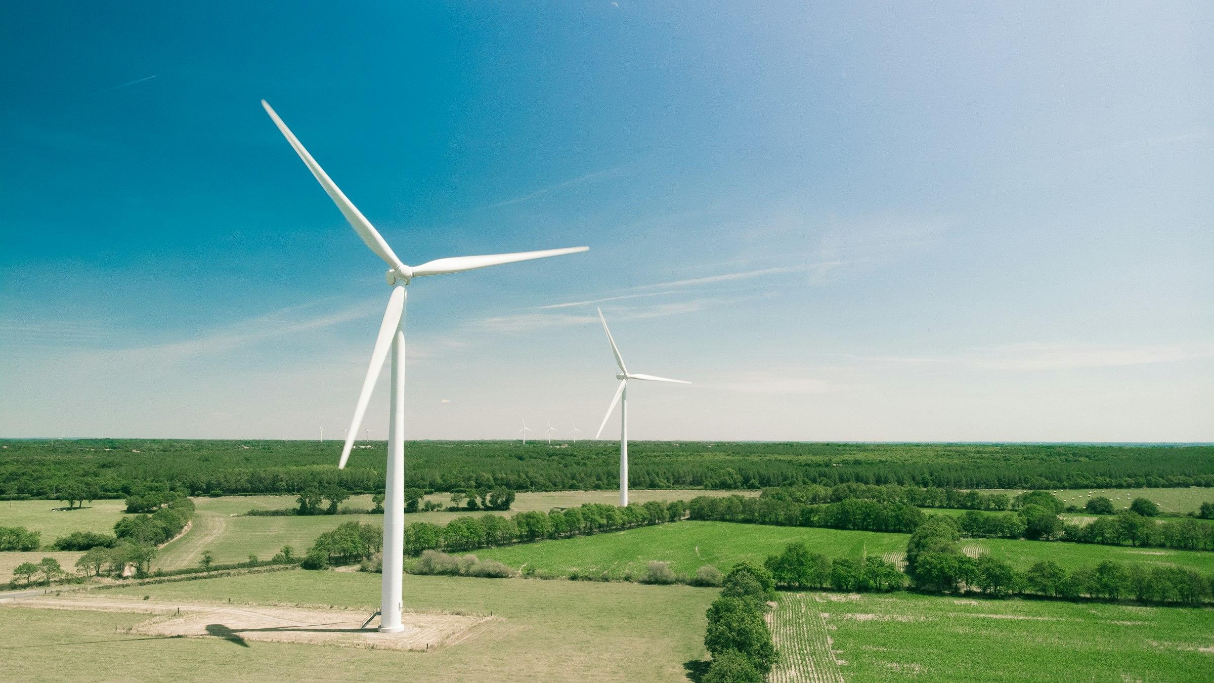 Wind turbine in a green field under a clear sky